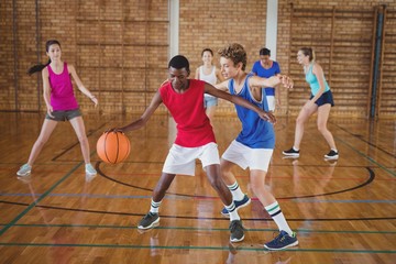 High school kids playing basketball in the court