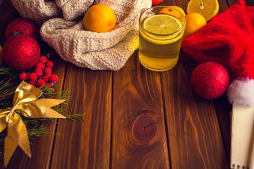 Tea with lemon on a wooden table with citrus fruits, orange, mandarin and garat. Ingredients for a Christmas drink
