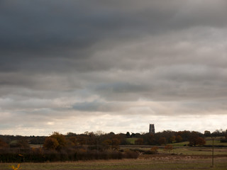 dramatic sky over open empty grassland plain special with church spire tower
