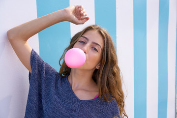 Brunette teen girl bubble gum in blue stripes wall