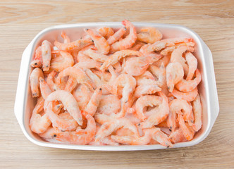 Frozen shrimps in ice. Many royal shrimps on an iron tray.