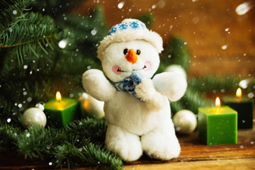 Knitted snowman on a branch of a Christmas tree. knitted Chrismas toys on green fir branches