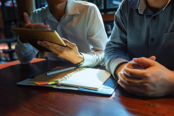 A picture of a business man sitting at a cafe talking in the afternoon of a bright day