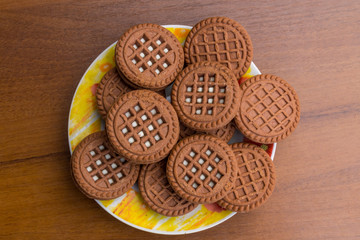 Chocolate cookies with cream filling on wooden table