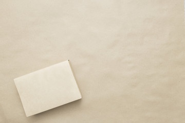 Craft paper wrapped gift with brown paper brown canvas background