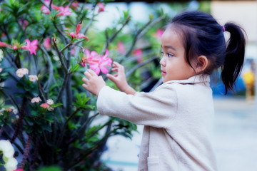 Cute little girl is blossoming flowers blooming in a bright winter day.