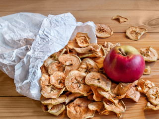 Dried and fresh apples lie in a paper bag