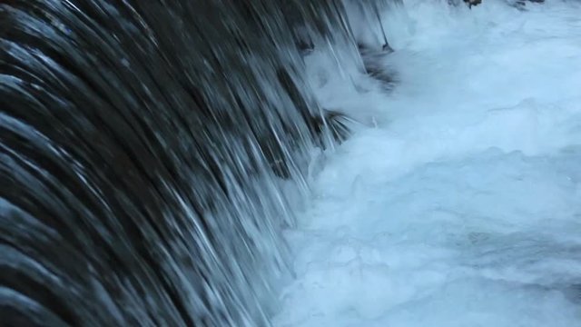 Powerful water stream flows down with foaming close-up (1080p, 25fps, sound)