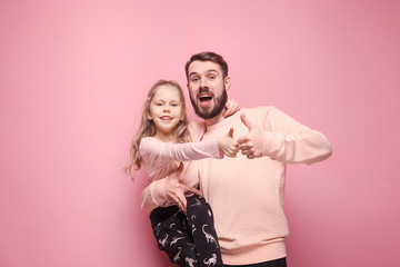 Young father with his baby daughter with thumb up