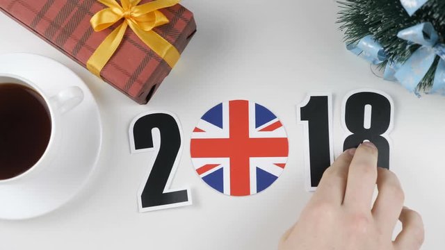 Illustration, new year, male hand changes the year from 2017 to 2018, England flag, cauntry ball.