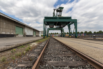 Riesiger, grüner Lastenkran auf Schienen im Containerhafen, Rückansicht