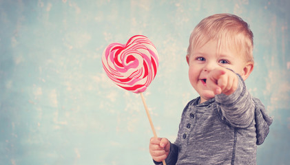 niedlicher lachender Junge mit Herz - Lolli