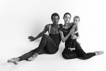 A happy family of ballet dancers on white studio background
