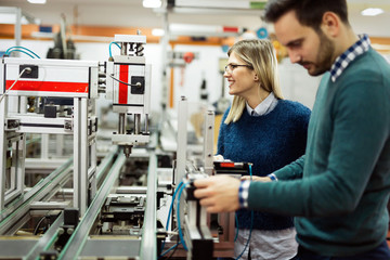 Young attractive students of mechatronics working on project
