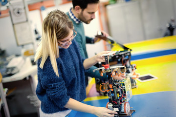 Young attractive students of mechatronics working on project