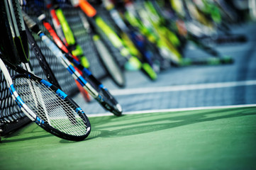 tennis rackets or tennis racquets leaning against tennis court background