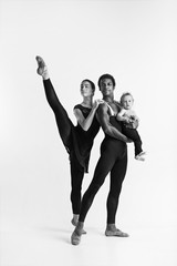 Fototapeta na wymiar A happy family of ballet dancers on white studio background