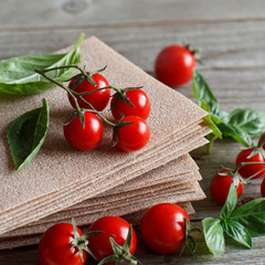 Raw lasagna sheets,basil and cherry tomatoes