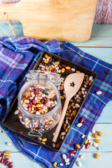 Beans mix in the jar and tray. Blue wooden table and background.