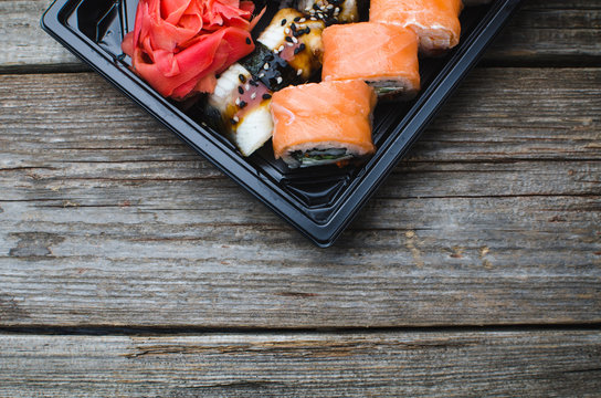 Sushi in a black container on a wooden table colorful and beautiful