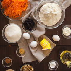 Baking ingredients on kitchen table. Products for filling carrot cupcakes prepare for cooking on wooden cutting board. Lifestile food concept.