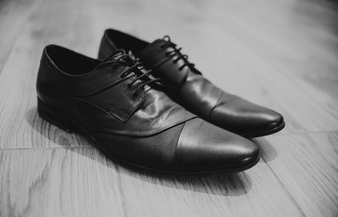 close up on black leather boots on wood, black and white, retro and vintage