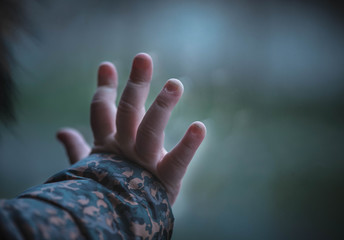 Baby is holding his hand on the window. 
