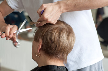 Fototapeta premium Men's hands cut their hair close-up