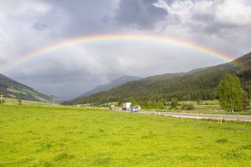 Rainbow above road and mountains