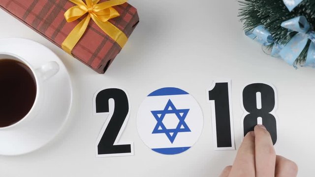 Illustration, new year, male hand changes the year from 2017 to 2018, Israel flag, cauntry ball.