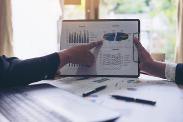financial Image of  business people pointing at business document presentation summary report , during discussion at meeting , Notebook on wood table