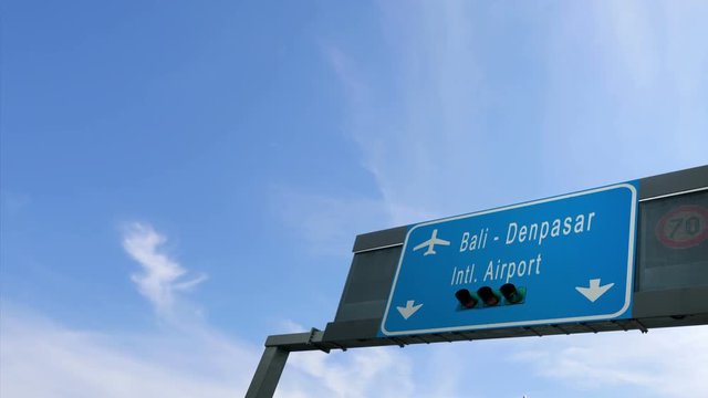 airplane flying over bali airport signboard