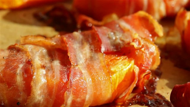 Pumpkin slices baked in a bacon wrapping - macro closeup, sliding camera