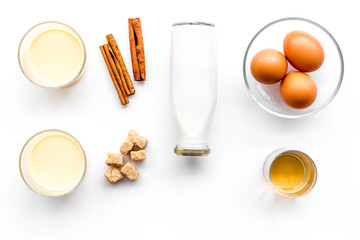 Plakat Ingredients for eggnog. Eggs, milk, cinnamon, whiskey on white background top view