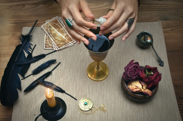 Woman witch prepare a magic potion. Future reading. Tarot cards on fortune teller desk table.