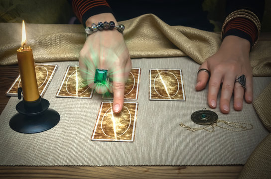 Tarot Cards And Fortune Teller Desk Table. Future Reading. Woman Fortune Teller Shows With Her Index Finger On Tarot Card.