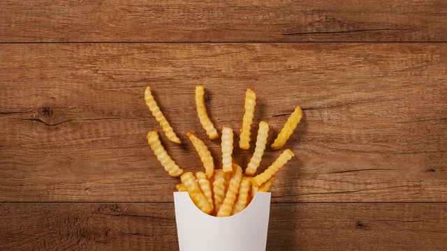 French fries filling a paper holder bag with ketchup and soda joining the menu - stop motion animation with copy space