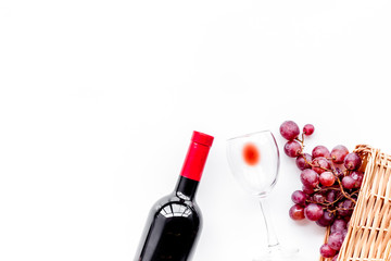Taste red wine. Bottle of red wine, glass and red grape on white background top view copyspace