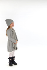 Kleines Mädchen in Winterkleidung schaut in eine Richtung und lacht