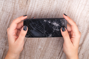 Smartphone with a broken screen in the girl's hand