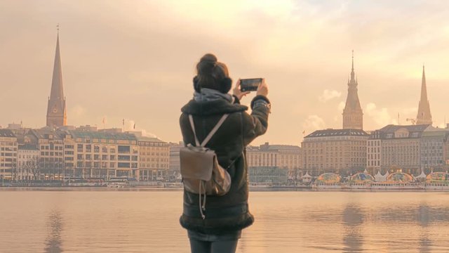 Tourist takes pictures of Alster Lake and Hamburg city panorama