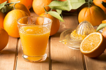 Glass with orange juice on the wooden table