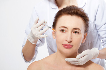 Plastic Surgery Concept. Doctor Hands Making Anti Aging Face Collagen Injection and Lifting Procedure Isolated on White Background. Copy Space and Mock Up. Macro Woman Face.