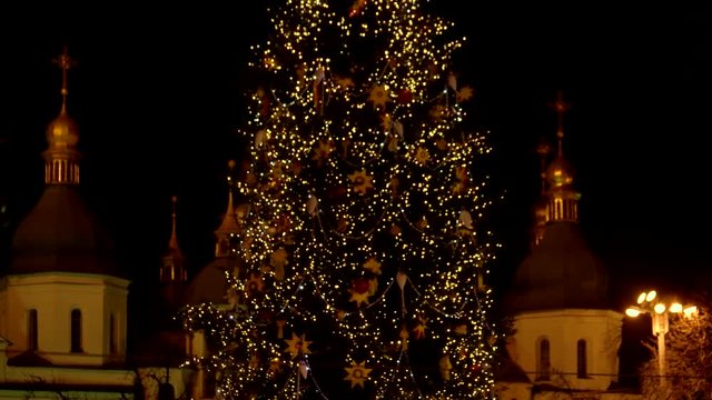 Middle of the flashing christmas tree. Orthodox church in the background.