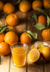 Glass with orange juice on the wooden table