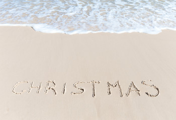 Fototapeta na wymiar Christmas sign on the beach sand tropical hot winter concept