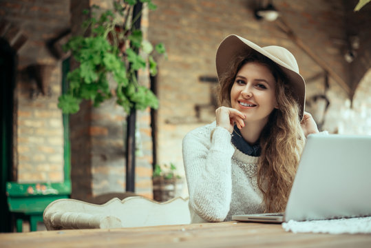 Portrait Of A Glamorous Young Woman With Laptop Computer While Sitting On A Bench.