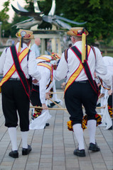 Traditional morris men dancing in the UK with sticks bells and musical instrument