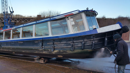 underside of boat being steam cleaned