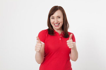 Smiling attractive middle aged woman showing thumbs up, okay on white background. Copy space.